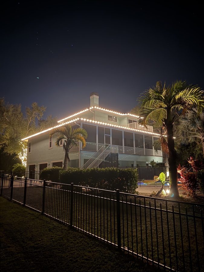 Same roofline at night with warm white lighting installed