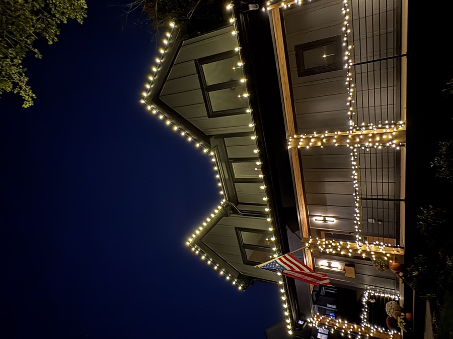 Modern farmhouse porch with railing wrapped in icicle lighting